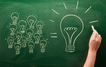 A hand draws a group of smaller light bulbs equating to one large light bulb on a chalkboard, symbolizing the combination of ideas into a bigger concept, much like the 7 Steps to SEO Success merging to form an effective strategy.