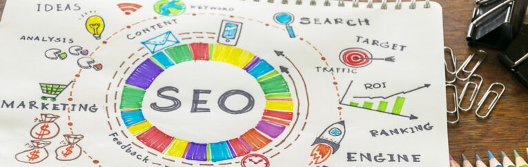 Hand-drawn SEO diagram on paper, illustrating various concepts such as content, traffic, ranking, engine, keywords, and targets with colorful sketches and arrows around a central "SEO" circle.