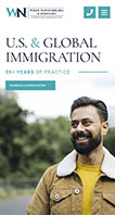 A man with a beard and a yellow shirt under a jacket smiles in front of a blurred green outdoor background. The text reads: "U.S. & Global Immigration - 35+ Years of Practice.