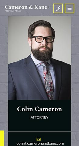 A man with glasses and a beard, wearing a suit and patterned tie, is pictured on a law firm's webpage. The firm’s name is Cameron & Kane, and the text identifies him as Colin Cameron, Attorney.