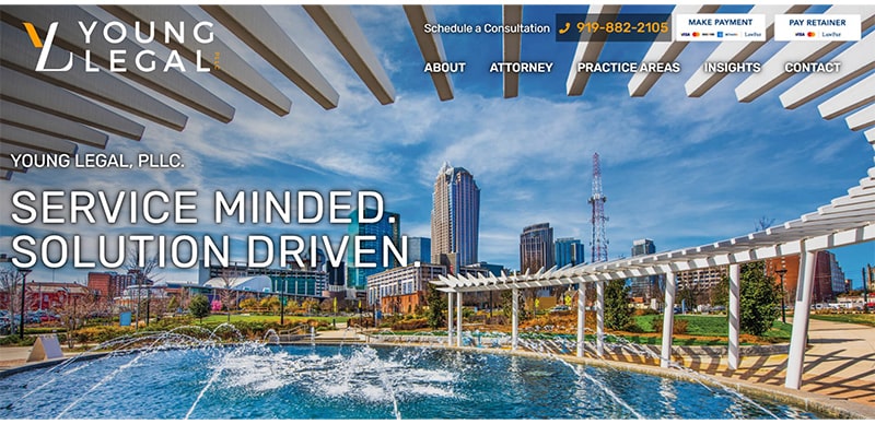 Legal firm's website homepage with a city skyline background and water fountain in the foreground. The text reads, "SERVICE MINDED. SOLUTION DRIVEN." and includes contact information at the top.